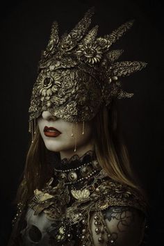 a woman wearing a mask with feathers and jewels on her head, in the dark