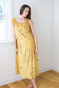 "antique 1920s vibrant citrine yellow silk velvet with all-over silver beaded \"bubble\" motif. tabard-style deep armholes, piped and gathered accents at the dropped waist. hooks-and-eyes close the top of the left shoulder. a rare and special example of 1920s finery. label: M-------'s Gowns, Paris France. sadly the label has deteriorated and made the maker's name difficult to read. someone may yet be able to solve it though! approx size: medium/large (should have a loose/draped fit) model wears Velvet Gown, Yellow Silk, High Hips, Silk Velvet, Dress Clothes For Women, Yellow Dress, Paris France, The Label, Citrine