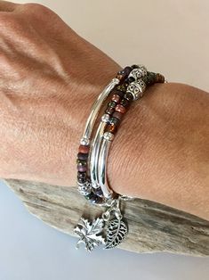 This Stunning Bohemian Style Bracelet/Necklace will be noticed and adored! Beautiful rich colors of browns, burgundy, wine, plum and Iris purple. Silver tube beads throughout with detailed Tibetan beads. High style bangle look! It's made to wrap around your wrist three times and connects with a lobster clasp. It has an extension chain to adjust to a tight or loose fit. You can choose a charm of your choice! Please see the last 3 Listing photos for your options. If choosing an Initial/Letter char Bohemian Multi-strand Beaded Bracelets With Silver Beads, Silver Bohemian Multi-strand Wrap Bracelet, Handmade Bohemian Beaded Bracelets For Layering, Bohemian Silver Wrap Bracelet With Colorful Beads, Bohemian Silver Wrap Bracelet With Spacer Beads, Bohemian Multi-strand Silver Beaded Bracelets, Bohemian Beaded Wrap Bracelet For Layering, Bohemian Wrap Bracelet For Layering, Bohemian Beaded Stackable Bracelets