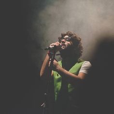 a man singing into a microphone on stage