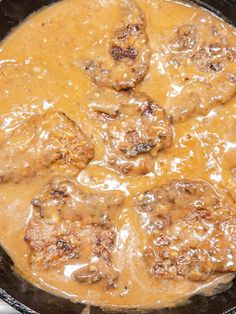 meatballs and gravy are cooking in a skillet