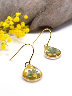 Keeping Aussie nature close to your heart is easy with these wattle teardrop earrings. The flowers are real and preserved in resin, so they stay fresh.  Made with hypoallergenic stainless steel, these wattle earrings are nickel-free and a great option for sensitive ears. A classic minimalistic teardrop shape, these earrings make a great gift for any nature lover in your life. Lightweight and durable, these sweet little earrings can be worn comfortably every day with any outfit! Eucalypse jewelle Nature-inspired Teardrop Birth Flower Earrings, Nature-inspired Teardrop Earrings With Pressed Flowers, Resin Birth Flower Drop Earrings, Resin Drop Earrings With Birth Flower Design, Handmade Resin Teardrop Earrings As Gift, Nature-inspired Teardrop Earrings For Gifts, Teardrop Flower Earrings With Ear Wire As Gift, Handmade Yellow Teardrop Earrings, Handmade Yellow Teardrop Earrings As A Gift