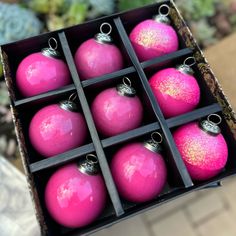 a box filled with pink ornaments on top of a table