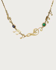 a gold necklace with green and blue stones