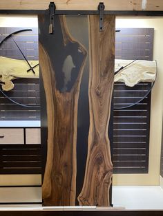 two pieces of wood sitting on top of a table in front of a wall mounted clock