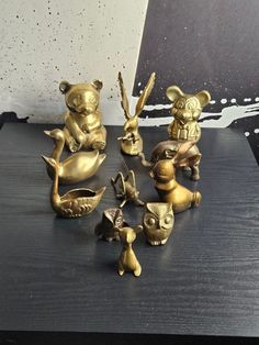 several brass figurines sitting on top of a table