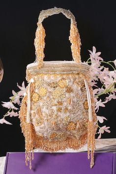 White velvet potli with floral, beads, crystal, dabka and swarovski hand embroidery. Comes with a detachable handle. - Aza Fashions Hand Embellished Pouch Bag For Reception, Hand Embellished Bags For Reception, Embellished Pouch Bag For Reception, Hand Embellished Potli Bag For Festivals, Hand Embellished Potli Bag For Festival Celebrations, Festive Hand Embellished Gold Bag, Festive Gold Hand Embellished Bag, Festive Gold Hand-embellished Bag, Luxury Embroidered Festive Bag