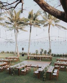 an outdoor setting with tables and chairs set up for a wedding reception at the beach