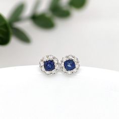 These beautiful stud earrings feature a pair of 0.30 carat wight Blue Sapphire gemstones with a halo of natural earth mined diamonds set in solid 14K gold. These Blue Sapphire studs make a lovely September birthstone gift for your loved ones! These earrings are made with solid 14k Gold and natural earth mined SI / G-H Diamonds. As listed, these earrings are ready to ship. If you're interested in purchasing this setting with a different center stone please message us! White Gold Round Gemstone Cluster Earrings, Sapphire Halo Diamond Earrings For Weddings, Sapphire Diamond Earrings With Halo Design For Wedding, Sapphire Round Cut Earrings With Halo Design, Sapphire Earrings With Halo Design, Sapphire Halo Design Round Cut Earrings, Sapphire Round Cut Earrings With Halo Setting, Sapphire Diamond Earrings With Halo Design, Sapphire Halo Setting Round Cut Earrings