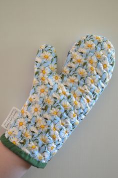 an oven mitt with white and yellow flowers on it