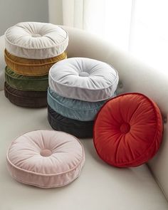 four round cushions sitting on top of a white couch