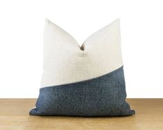 a blue and white pillow sitting on top of a wooden table