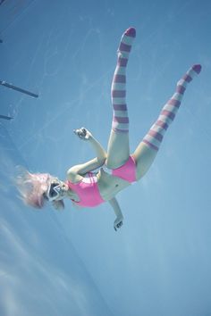 a woman in pink swimsuit flying through the air