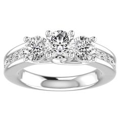 a three stone engagement ring with diamonds on the band and side stones in the setting