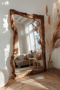 a mirror sitting on top of a wooden floor next to a white couch in a living room