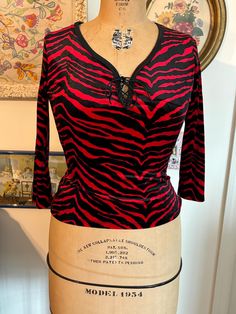 New old stock 90s funky top. Ties at chest. Tag says M but I'd say this would fit a modern 4/6.  Measurements taken with top lying flat: 16.5 inches pit to pit 12 inches across waist  20 inches top to bottom Passing through my smoke free, cat friendly home. Retro V-neck Stretch Top, Stretch 90s Tops For Fall, Stretch 90s Style Tops For Fall, Stretch Tops For Fall In 90s Style, Retro Fitted Black Top, Fitted Retro Black Top, Black Fitted Retro Top, Fitted Black Retro Top, Fitted 90s Tops For Fall