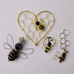 four different types of wire and bead brooches in the shape of a heart