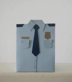 a paper cut out of a man's shirt and tie on top of a table