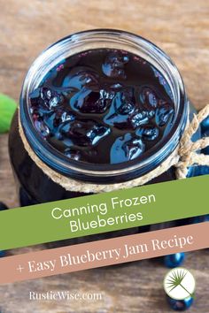 a jar filled with blueberry jam sitting on top of a wooden table