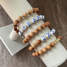 * Product Details* * This listing is for any ONE bracelet from the choices listed below: - (1) 8mm wooden stacking bracelet with 4mm gold filled spacer beads. - (1) 8mm wooden stacking bracelet with white and blue floral porcelain beads with 4mm gold filled spacer beads. - (1) 8mm solid wooden stacking bracelet - (1) 8mm wooden stacking bracelet with 4mm gold filled spacer beads -(1) 8mm wooded stacking bracelet with 6mm gold filled beads. * This listing includes ONE bracelet. Any images shown with multiple bracelets is to be used to show the different styles that you may choose from. *Please measure your wrist before ordering for accurate sizing! We do not offer returns or exchanges for size issues. *Need a different size than listed?  Please send me a message! *ALL ORDERS ARE FINAL SALE Wood Bracelets Women, Wooden Beaded Bracelets As Gift, Wooden Beaded Bracelets Perfect For Gifts, Wooden Bracelets With Round Beads For Gifts, Handmade Beaded Wood Bracelets In Natural Wood Color, Natural Wood Beaded Bracelets As Gift, Wooden Beaded Bracelets For Gifts, Natural Wood Beaded Bracelets For Gifts, Natural Wood Beaded Bracelet As Gift