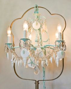 a chandelier with seashells and candles on it