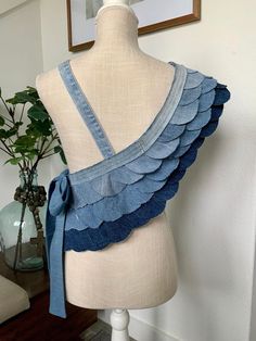 a mannequin wearing a blue top with ruffles