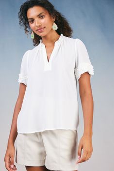 The silhouette of this short-sleeve blouse may be simple, but pleated trim and layered ruffle detailing set it apart. Featuring a split neckline with gentle gathers, the popover style elevates your look with minimal effort. •Split neckline •Short sleeves •Pleated trim with ruffle detailing •Relaxed fit Item number 2330159 100% Polyester Gentle Cycle Cold Spring Workwear Short Sleeve Top In Neutral Color, White Ruffle Hem Blouse For Work, Feminine Flutter Sleeve Blouse, Elegant Flutter Sleeve Blouse For Work, Short Sleeve Ruffle Hem Top For Work, Chic Short Sleeve Blouse With Ruffle Hem, Short Sleeve Top With Ruffle Hem For Work, Feminine Short Sleeve Blouse With Ruffles, Feminine Short Sleeve Tops With Ruffles