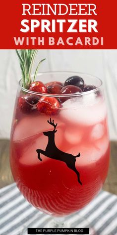 a drink in a glass with cherries and rosemary sprig on the rim