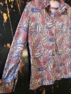 "Epic women's vintage 70's golden brown and periwinkle on beige paisley print polyester button down shirt. The very best color and paisley print! Blue abalone buttons. Double button cuffs. Silky and soft polyester fabric. Fold down pointed lapel. Excellent vintage condition! Union made tag. Size women's large. Measurements laying flat: fabric has stretch. Length: 21\" Armpit to armpit: 27\" Sleeve length: 23.5\"" Vintage Button-up Top With Paisley Print, Vintage Paisley Print Button-up Top, Fitted Button-up Paisley Print Blouse, Vintage Long Sleeve Blouse With Paisley Print, Vintage Long Sleeve Paisley Print Blouse, Patterned Paisley Print Button-up Blouse, Fall Paisley Print Button-up Blouse, Union Made, Trapeze Dress