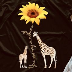 two giraffes and a sunflower on a black background