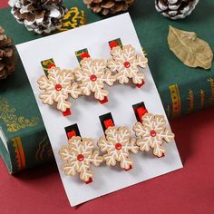 three wooden snowflakes sitting on top of a book next to pine cones