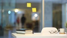 a table with some books, glasses and a potted plant sitting on top of it