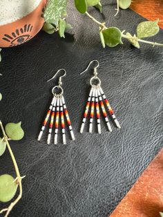 Southwest Sunset Fringe Dangle Earrings Design: These earrings are very lightweight, colorful and playful in a southwest inspired style.  Featuring 5 hand beaded head pins dangling from a silver finish ring and fishhook earring backing. Length: Approx. 2.5" drop length Colors: These beaded earrings feature a sunset like fade of glossy white, black, red, orange, yellow shimmer, white, and silver high quality glass beads hand strung onto silver finish nickel free metal components. **Notice: All earrings are FINAL SALE due to health standards. ** Photo disclaimer: All bead design will remain as pictured; color richness could vary.  Colors may vary depending on screen resolutions and devices viewing this listing.  All item photos and videos are taken on iPhone in a natural light setting to sta Sunset Minimalist, Southwest Sunset, Earrings Western, Minimalist Bar, Beaded Earrings Native, Bead Dangle Earrings, Western Earrings, Earrings Design, Fish Hook Earrings