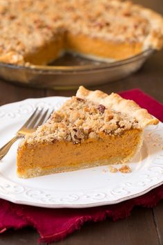 a slice of pie on a white plate with a fork in front of the pie