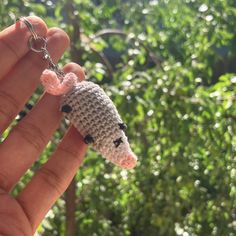 a tiny crocheted animal keychain being held by someone's hand