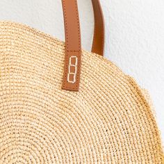 IN STOCK FAST SHIPPING FROM LOS ANGELES Step out in style with our versatile and spacious round tote bag! Made from durable raffia straw, this bag is perfect for both work and play. Featuring a genuine leather strap, it is designed to last and hold all your essentials. A must-have for your summer adventures, this popular shoulder tote is both functional and fashionable. Natural soft raffia straw Genuine leather straps Handmade Unlined Size: 14" Diameter x 5" Depth Strap drop length: 9" Designer Leather Straw Bag With Round Handle, Straw Bag With Woven Leather And Round Handle, Round Handle Straw Bag With Woven Leather, Eco-friendly Straw Bag With Round Leather Handles, Eco-friendly Straw Shoulder Bag With Handles, Straw Bags, Raffia Bag, Summer Adventures, Denim Bag