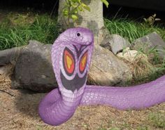 a purple snake statue sitting on the ground