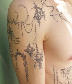 the back of a man's arm with tattoos on it and writing all over his body