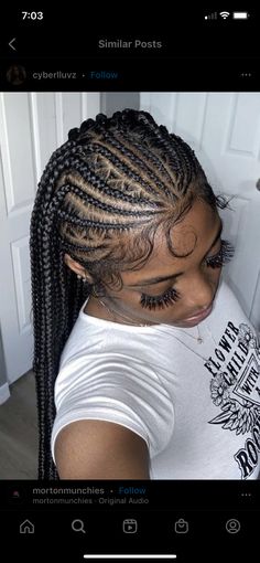 a woman with long cornrows wearing a white t - shirt