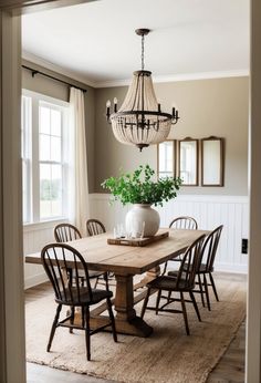 a dining room table with chairs and a chandelier hanging from it's ceiling