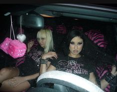 two women sitting in the back seat of a car