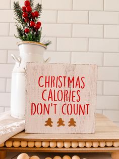 a wooden sign that says christmas calories don't count on top of a table