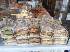 a display case filled with sandwiches and pastries