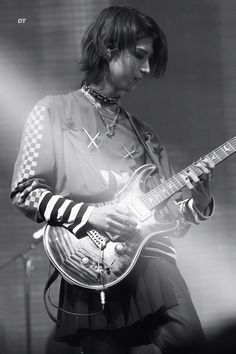 a woman playing an electric guitar on stage