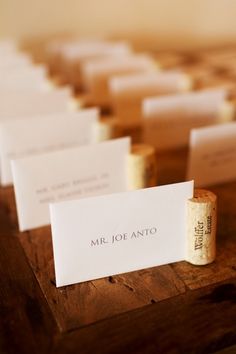 small business cards are placed on top of wine corks for guests to write their names