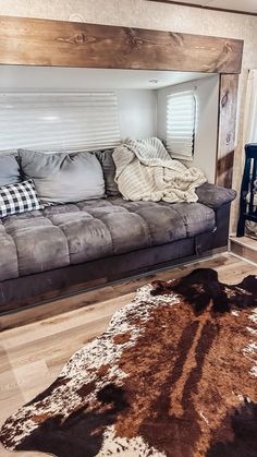 a living room filled with furniture and a cow hide rug on the floor in front of it