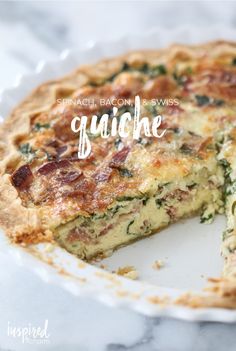 a quiche with spinach, bacon and cheese is shown on a white plate