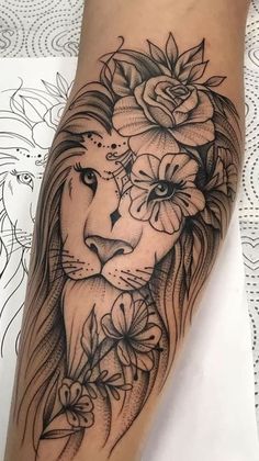 a woman's leg with a lion and flowers on it