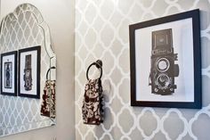 a bathroom with two framed pictures on the wall and a camera hanging on the wall