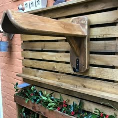 a wooden pallet filled with lots of greenery next to a wall mounted clock